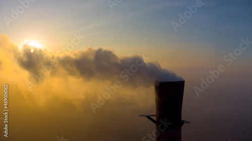 Chimney with smoke on a background of sunrise