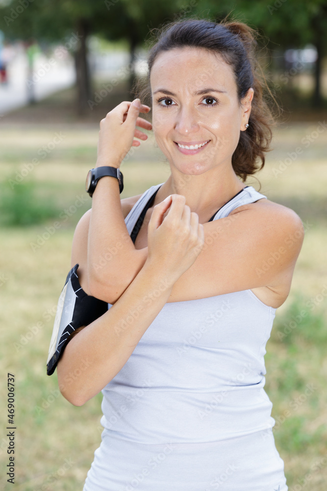 portrait of a smiling fitness woman stretching arms outdoor portrait of a smiling fitness woman stretching arms outdoor