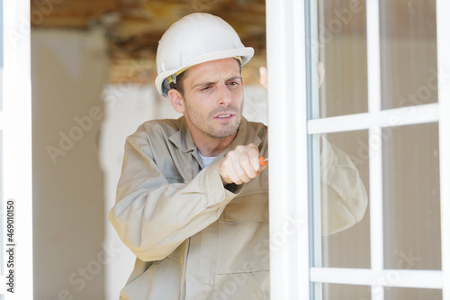 a contractor installing window blinds