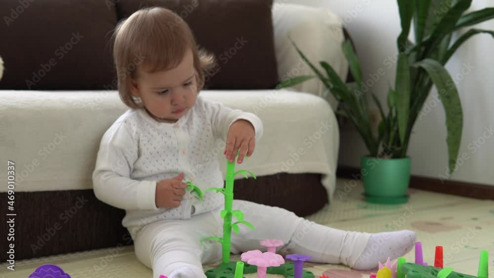 happy funny kid curly baby girl with educational toy blocks flowers. Children play at day care or preschool. Mess in kids room. Toddler build tower in kindergarten. Child playing with colorful toys happy funny kid curly baby girl with educational toy blocks flowers. Children play at day care or preschool. Mess in kids room. Toddler build tower in kindergarten. Child playing with colorful toys