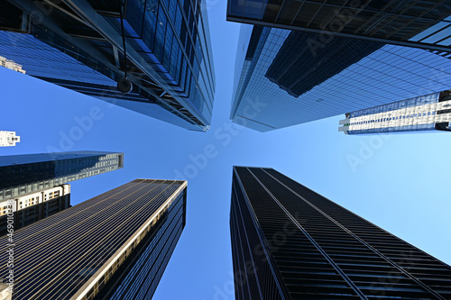 Upward view of skyscrapers in New York City, New York against clear blue sky.