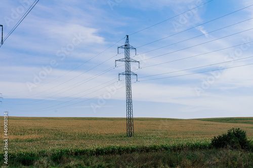 Electric power transmission lines at sky background, autumn field