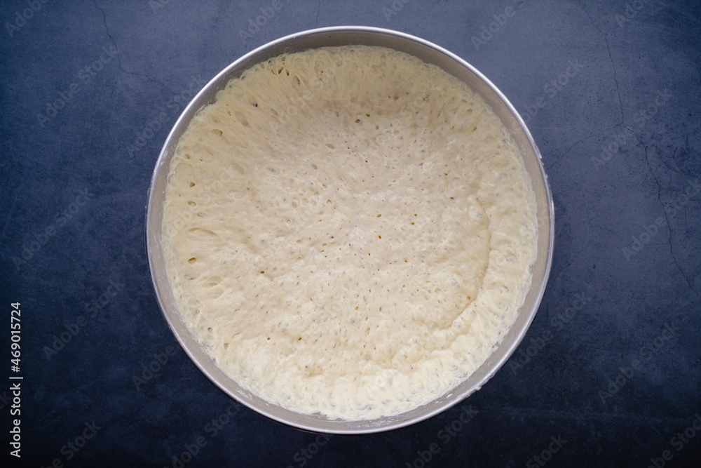 Uncooked Bread Dough in a Mixing Bowl: Rising French bread baguette dough in a stainless steel metal mixing bowl Uncooked Bread Dough in a Mixing Bowl: Rising French bread baguette dough in a stainless steel metal mixing bowl