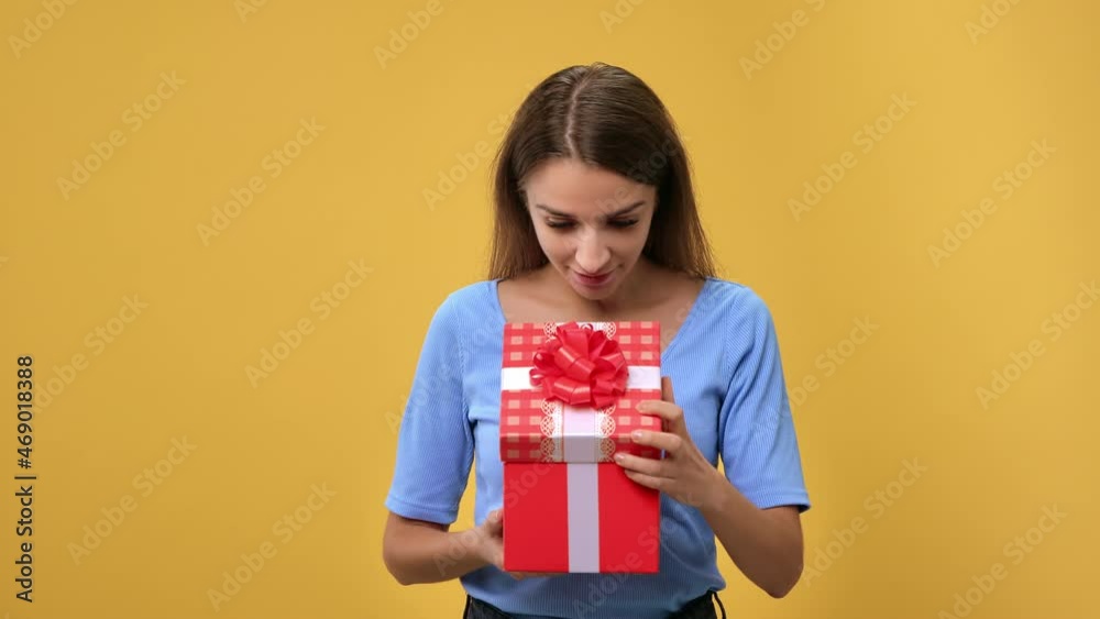 Portrait shocked woman opening festive gift box with desired present laughing posing isolated orange Portrait shocked woman opening festive gift box with desired present laughing posing isolated orange