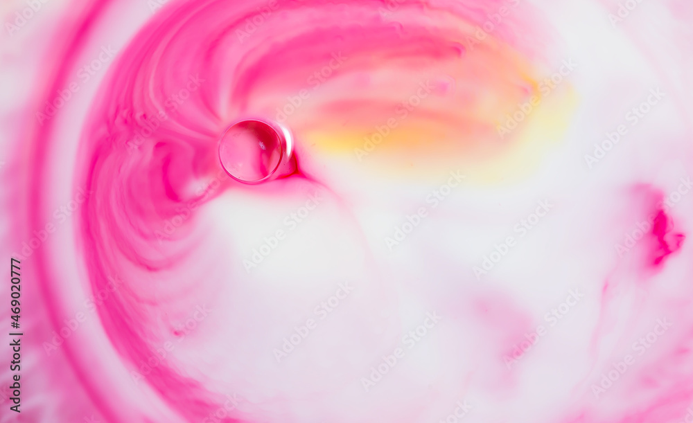 Abstract milk surface art effect of pink agradient  colour swirls added to milk to create an interesting background.