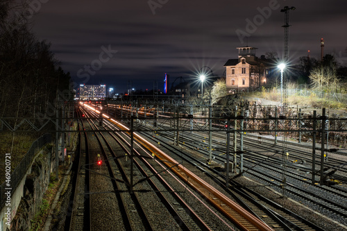 Bypassing trains casting light trails on the railtracks with beautiful city skyline on the background. photo
