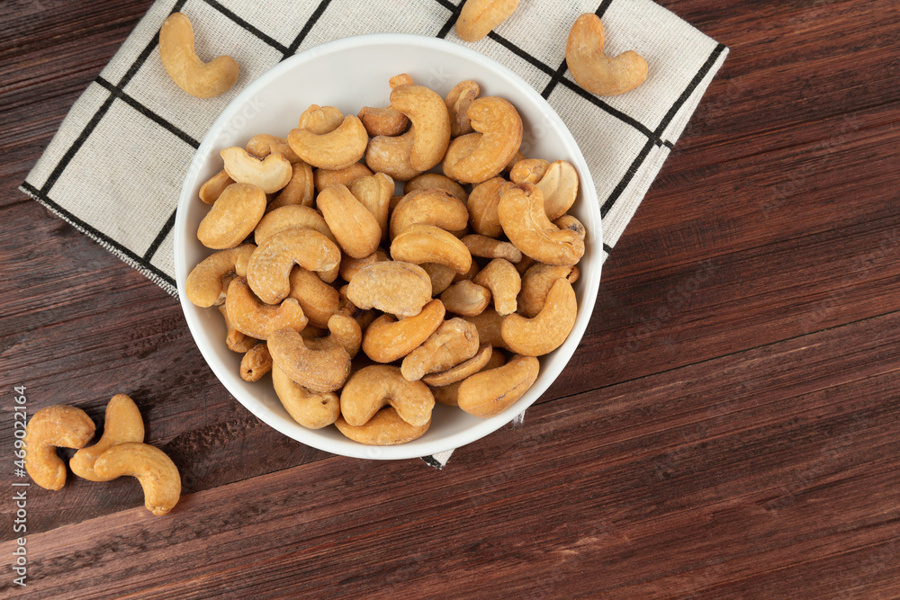 Top view of cashew nuts in white bowl on the table, Flat lay, Healthy snack, Vegetarian food. Top view of cashew nuts in white bowl on the table, Flat lay, Healthy snack, Vegetarian food.