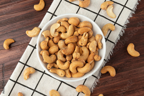Top view of cashew nuts in white bowl on the table, Flat lay, Healthy snack, Vegetarian food.