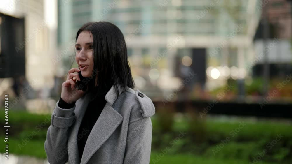 middle-aged brunette woman is calling by cellphone on street, portrait of businesswoman middle-aged brunette woman is calling by cellphone on street, portrait of businesswoman