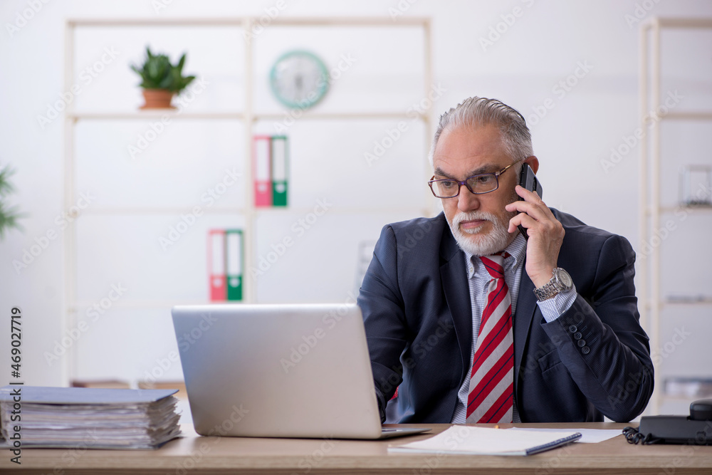 Old male employee working in the office Old male employee working in the office