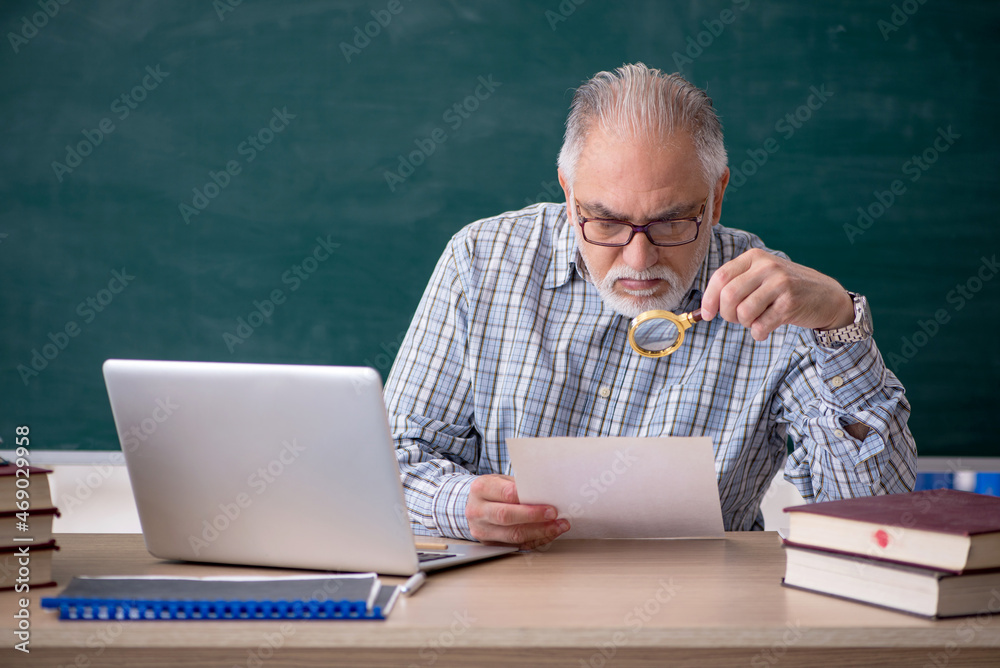 Old male teacher in the classroom Old male teacher in the classroom