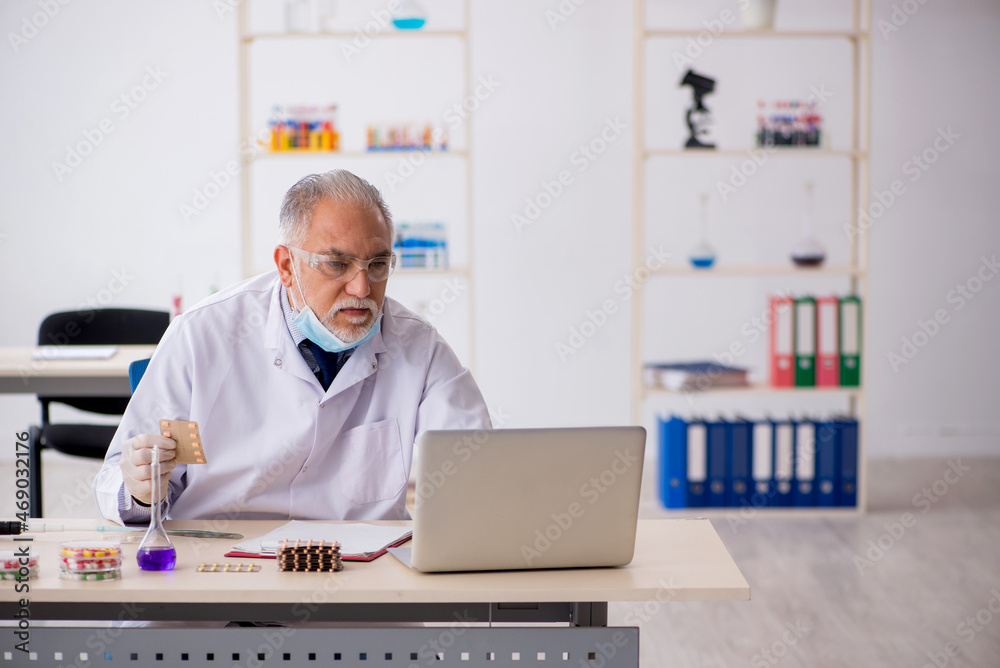 Old male chemist in drug synthesis concept