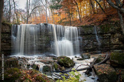 The blurred water of Terrace Falls, one of several waterfalls in Short Hills Provincial Park near St. Catherines, Ontario, cascades over a small cliff in a forest. photo