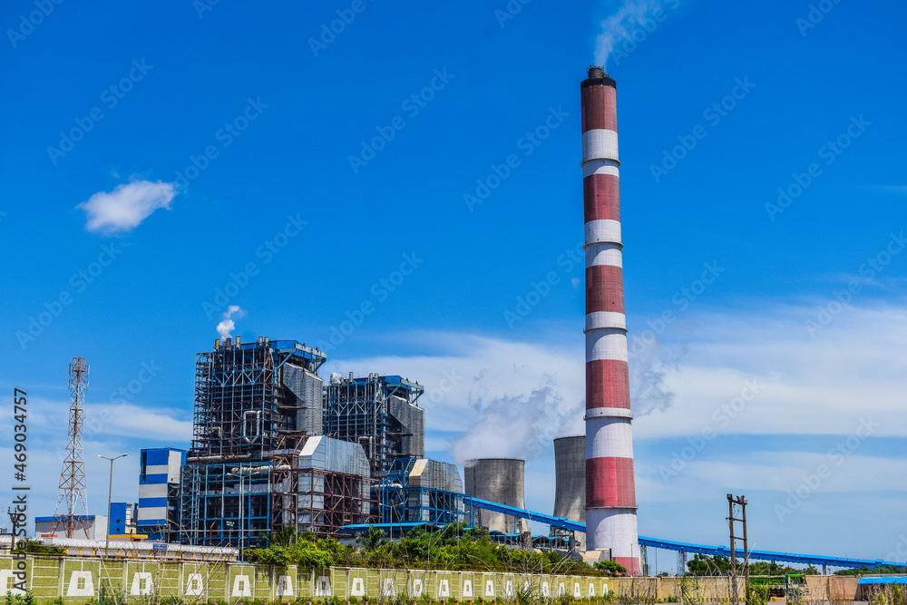 the chimneys of the thermal power station with white clouds of steam and Cooling tower of thermal power plant at neyveli, India the chimneys of the thermal power station with white clouds of steam and Cooling tower of thermal power plant at neyveli, India