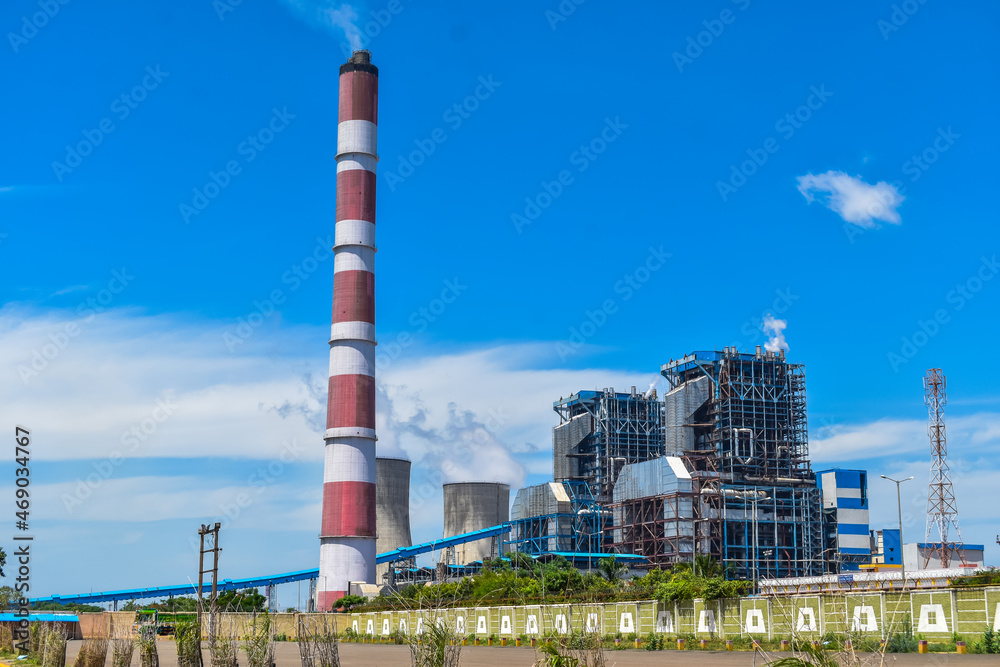 the chimneys of the thermal power station with white clouds of steam and Cooling tower of thermal power plant at neyveli, India the chimneys of the thermal power station with white clouds of steam and Cooling tower of thermal power plant at neyveli, India