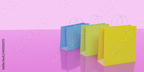 3d render. Blue, green and yellow paper shopping bags on a pink background. Top view, close-up. Reflection.