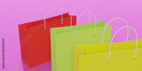 3d render. Red, green and yellow paper shopping bags on a pink background. Top view, close-up.