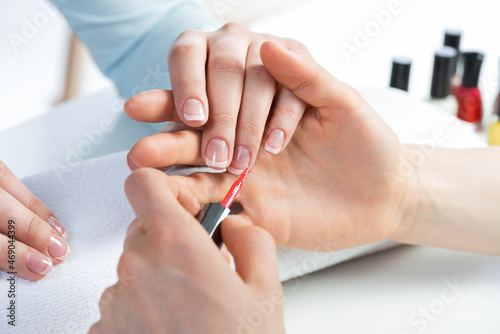 Woman receiving manicure by nail beautician