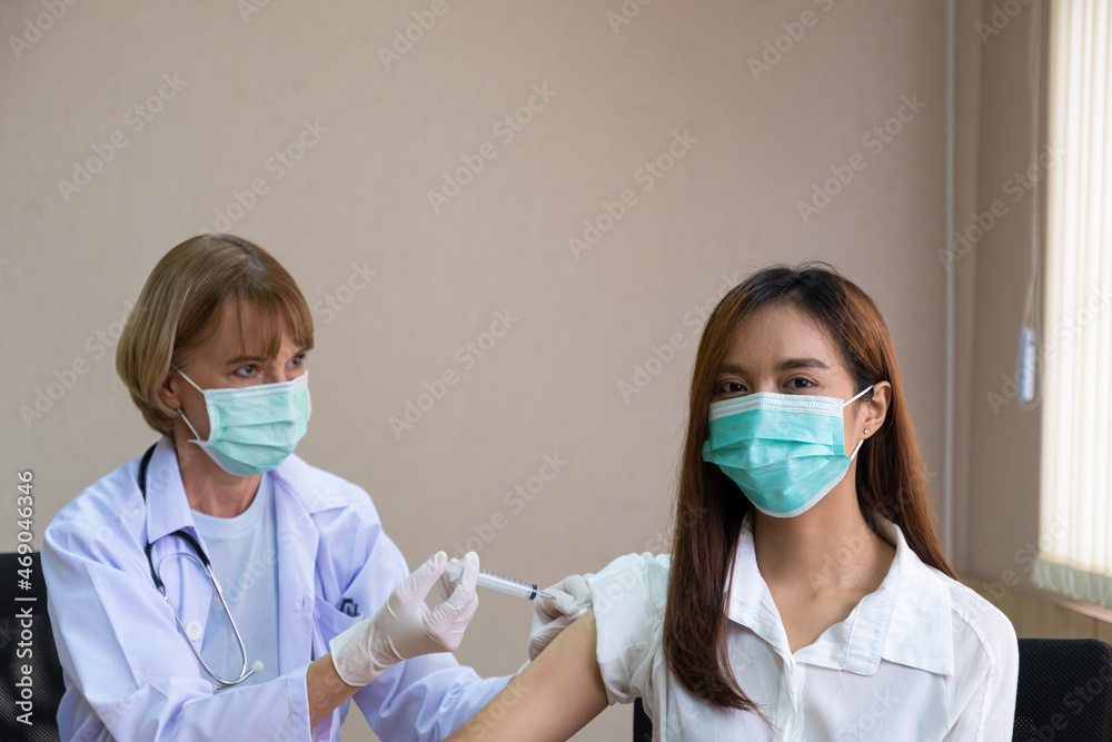 Selective focus at patient face. Doctor using syringe to inject vaccine into women patient arm. Healthcare, immunity for illness or Covid-19 prevention. Selective focus at patient face. Doctor using syringe to inject vaccine into women patient arm. Healthcare, immunity for illness or Covid-19 prevention.