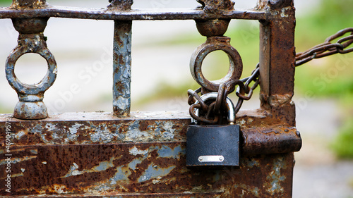 Fotografie Rusty old padlock on metal gate closeup