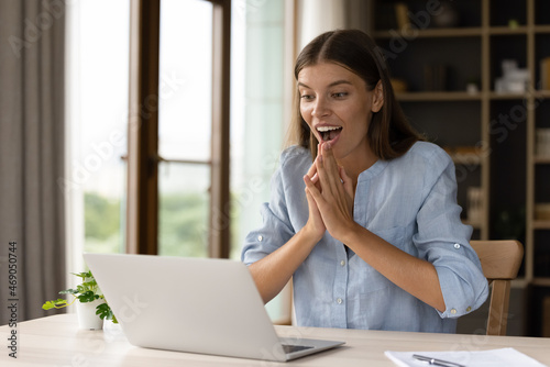 Happy surprised young businesswoman looking at computer screen, feeling excited celebrating professional achievement or online success in office, getting email with job offer or new career opportunity