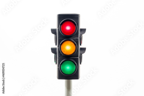 Isolated traffic light showing an illuminated red, amber and, green light.  Concept image illustrating possible confusion over decision making.