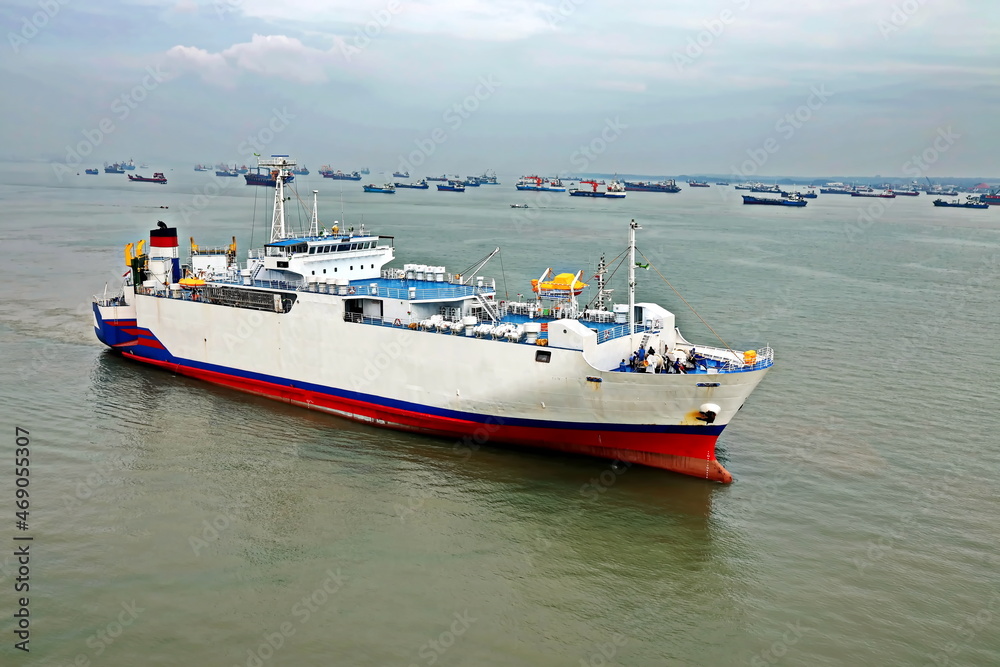 Vessels, passenger ships and tugboats in port under cargo operations and underway. Port of Surabaya, Indonesia, January,2021