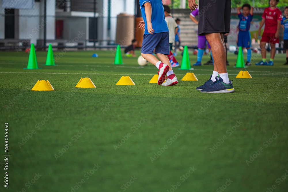 Obraz premium Soccer ball tactics on grass field with cone for training in background Training children