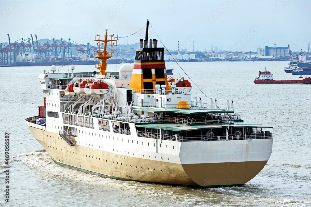 Fototapeta premium Vessels, passenger ships and tugboats in port under cargo operations and underway. Port of Surabaya, Indonesia, January,2021