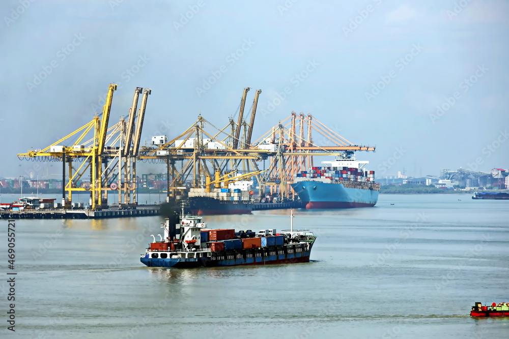 Naklejka premium Vessels, passenger ships and tugboats in port under cargo operations and underway. Port of Surabaya, Indonesia, January,2021