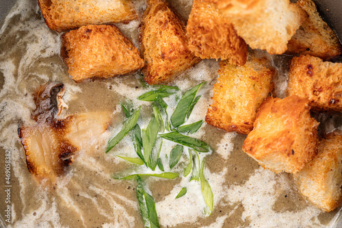 Closeup on mushroom cream soup with croutons and spring onion