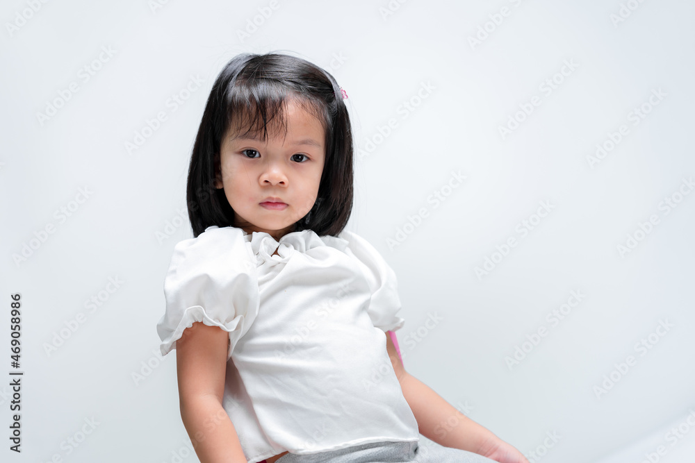 Girl waited in chair. Child are upset. Children wear white shirts. White background for inserting text. Girl waited in chair. Child are upset. Children wear white shirts. White background for inserting text.