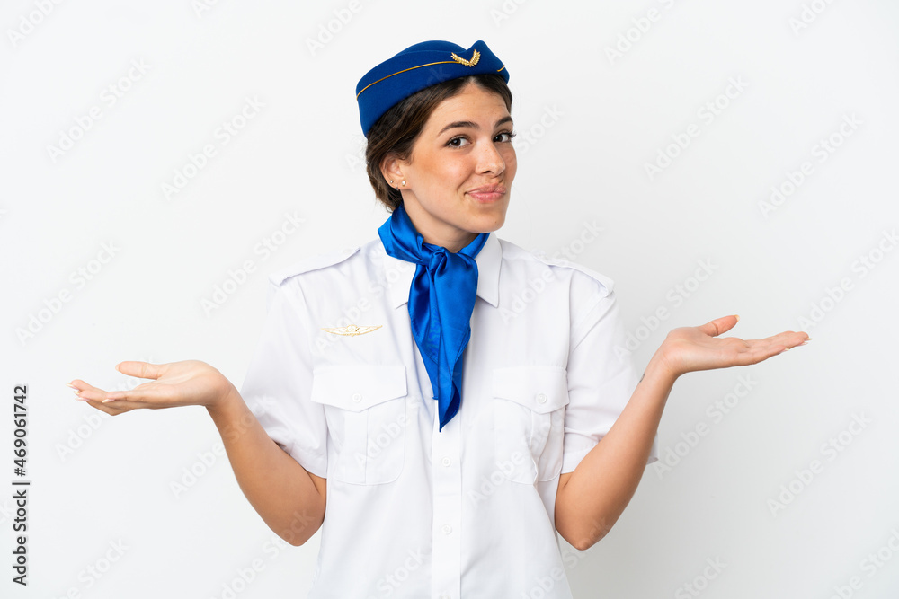 Airplane stewardess caucasian woman isolated on white background having doubts while raising hands