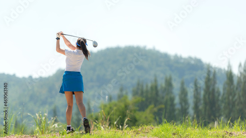 Golfer sport approach on course golf ball fairway. People lifestyle woman playing game golf tee of on the green grass.  Asia female player game shot in summer.  Healthy and Sport outdoor