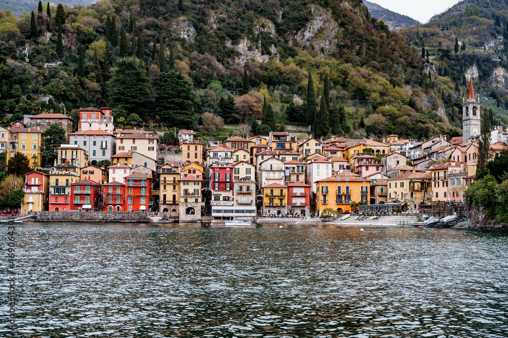 Colorful houses on the coast of Varenna against the backdrop of high mountains. Italy