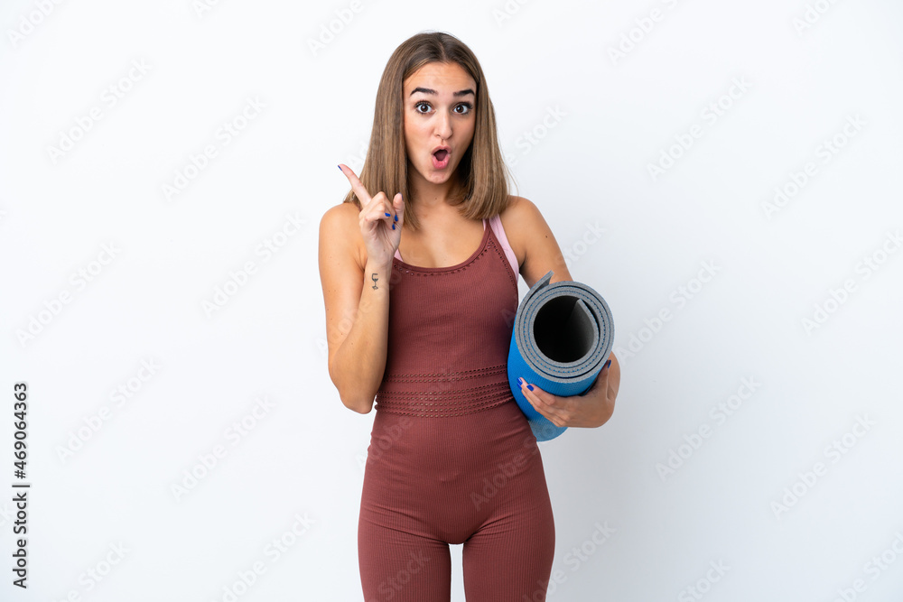 Young sport caucasian woman going to yoga classes isolated on white background intending to realizes the solution while lifting a finger up
