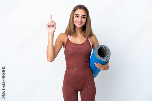 Young sport caucasian woman going to yoga classes isolated on white background pointing up a great idea © luismolinero