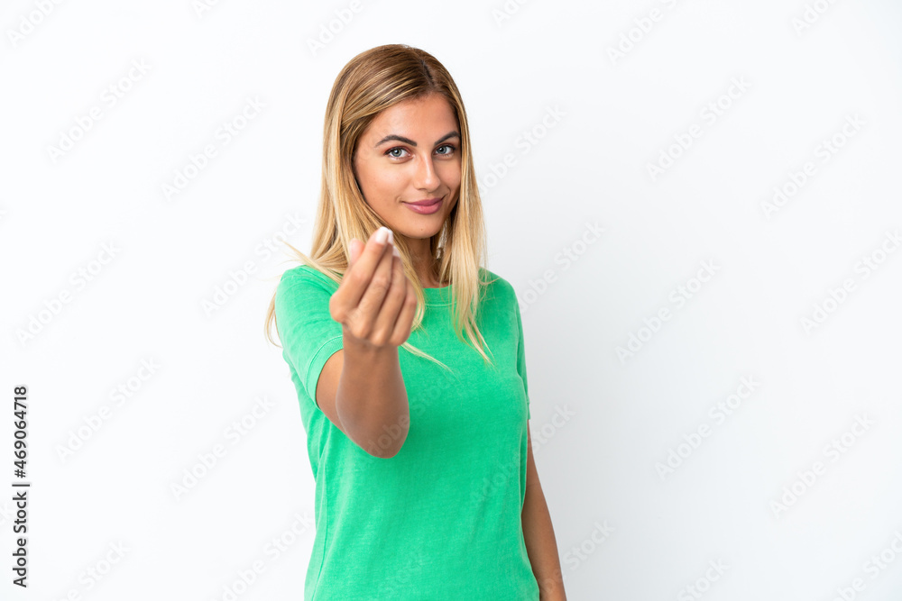 Blonde Uruguayan girl isolated on white background making money gesture Blonde Uruguayan girl isolated on white background making money gesture