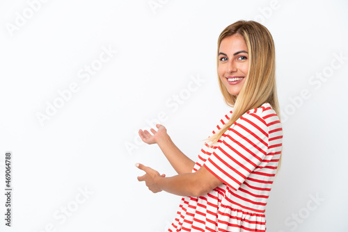 Blonde Uruguayan girl isolated on white background extending hands to the side for inviting to come