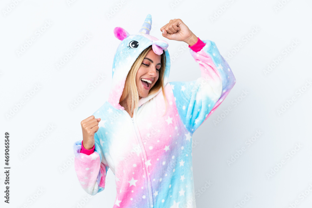 Blonde Uruguayan girl wearing a unicorn pajama isolated on white background celebrating a victory Blonde Uruguayan girl wearing a unicorn pajama isolated on white background celebrating a victory