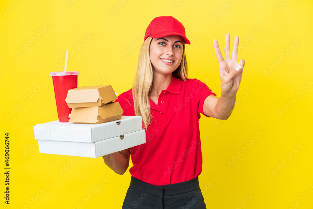 Delivery Uruguayan woman holding fast food isolated on yellow background happy and counting three with fingers Delivery Uruguayan woman holding fast food isolated on yellow background happy and counting three with fingers