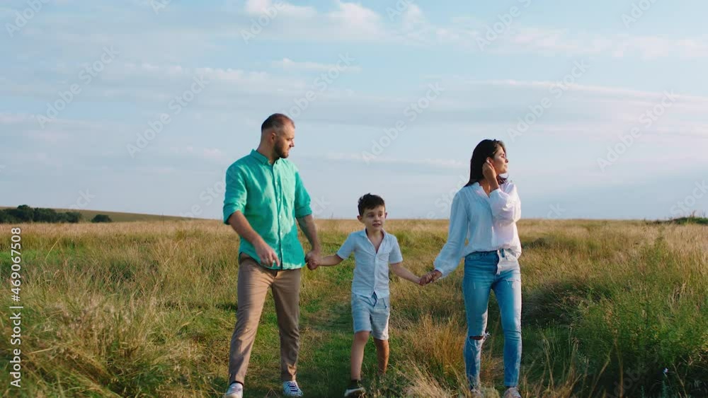Beautiful moments of a young family parents and one cute little boy enjoy the sunset and feeling the wonderful of nature together walking in front of the camera holding hands. Shot on ARRI Alexa Mini. Beautiful moments of a young family parents and one cute little boy enjoy the sunset and feeling the wonderful of nature together walking in front of the camera holding hands. Shot on ARRI Alexa Mini.
