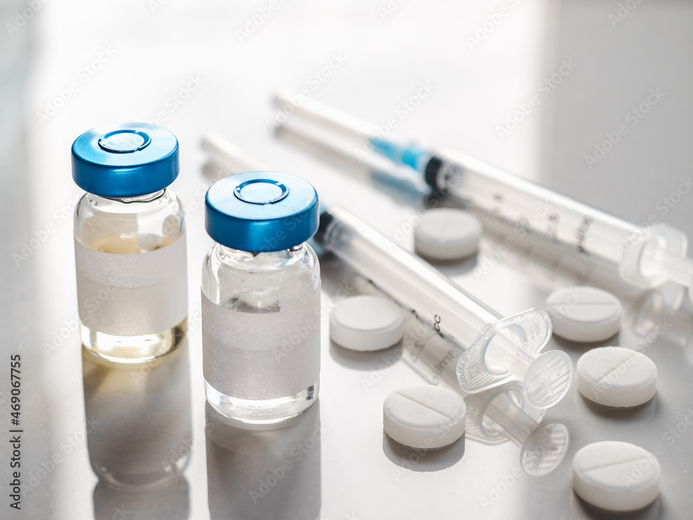 Syringes, injection bottles and tablets lying on the table. Close-up, indoors, view from above. Day light, studio photo. Healthcare concept Syringes, injection bottles and tablets lying on the table. Close-up, indoors, view from above. Day light, studio photo. Healthcare concept