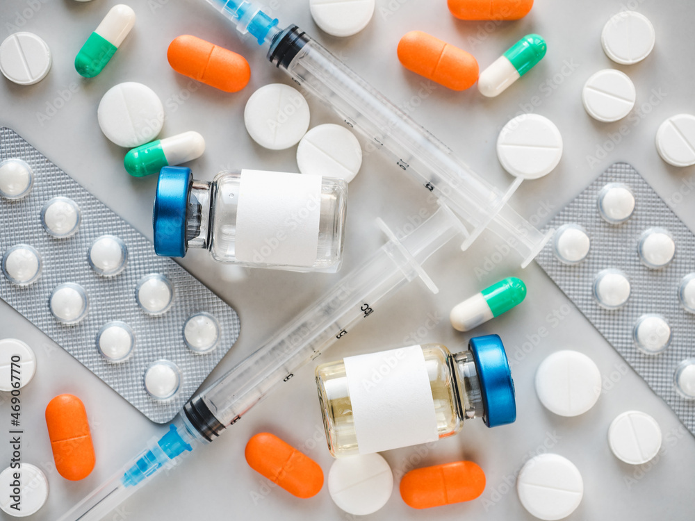 Syringes, injection bottles and tablets lying on the table. Close-up, indoors, view from above. Day light, studio photo. Healthcare concept Syringes, injection bottles and tablets lying on the table. Close-up, indoors, view from above. Day light, studio photo. Healthcare concept