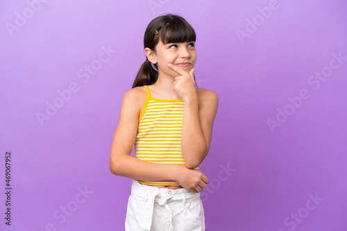 Little caucasian kid isolated on purple background thinking an idea while looking up