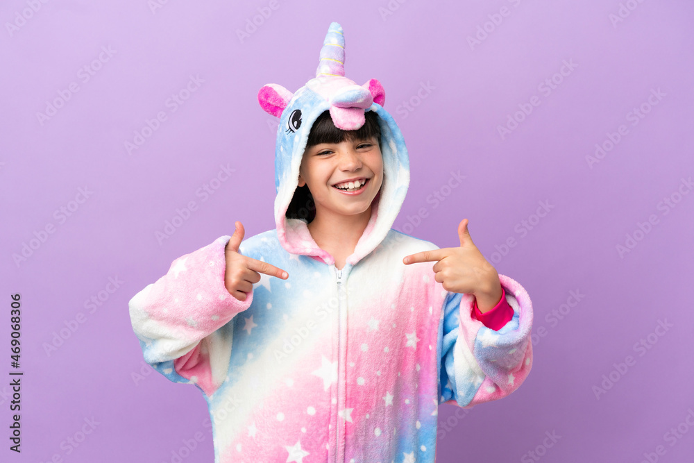 Little kid wearing a unicorn pajama isolated on purple background proud and self-satisfied