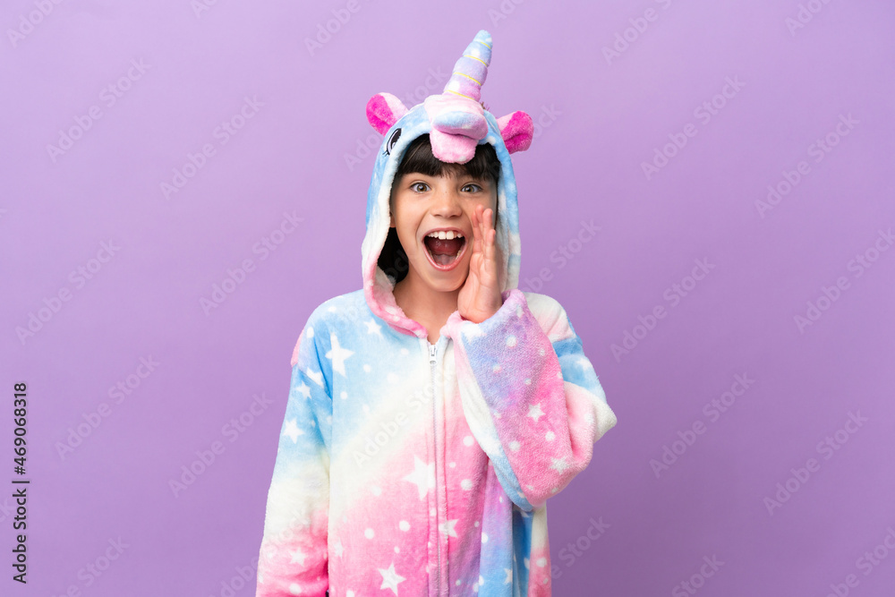 Little kid wearing a unicorn pajama isolated on purple background with surprise and shocked facial expression Little kid wearing a unicorn pajama isolated on purple background with surprise and shocked facial expression