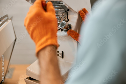 Male hands repairing coffee machine in cafe