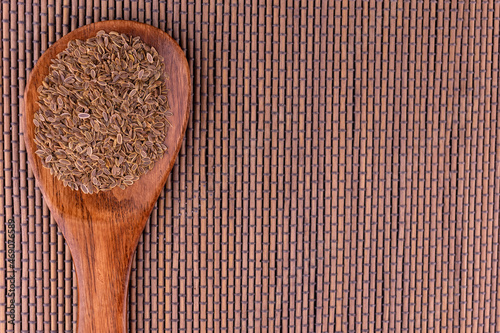 Dill seeds in a wooden spoon. Copy space. photo