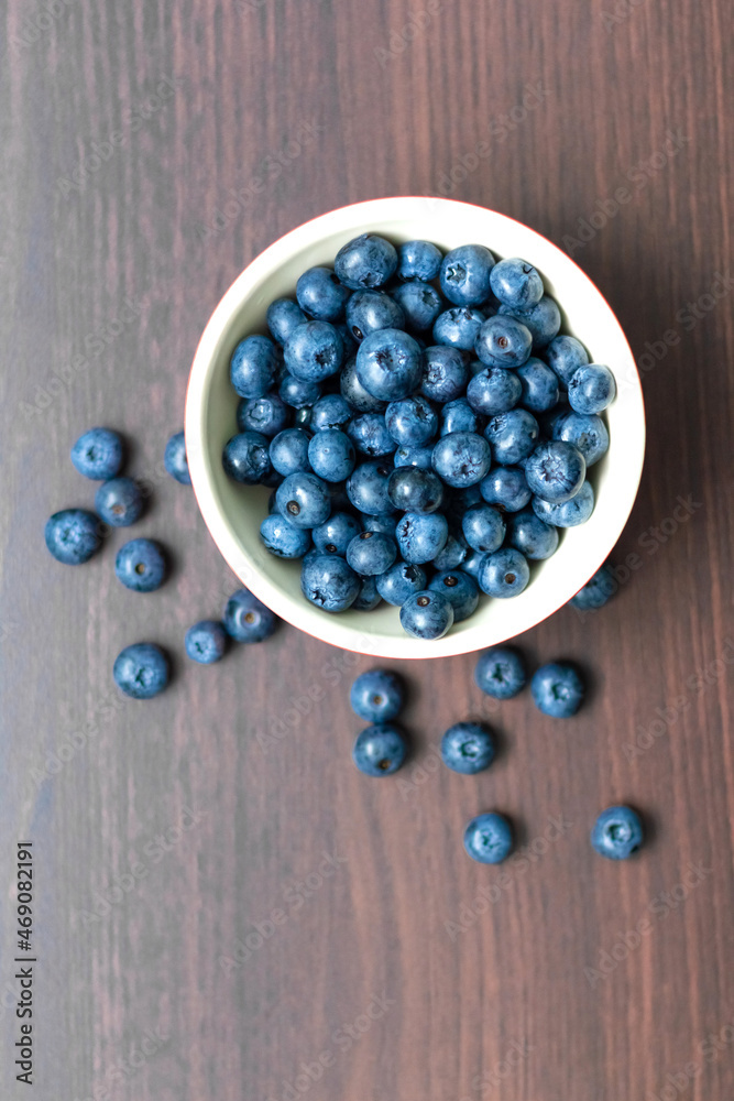 Blueberries in a red bowl on wooden table. Blueberries in a red bowl on wooden table.